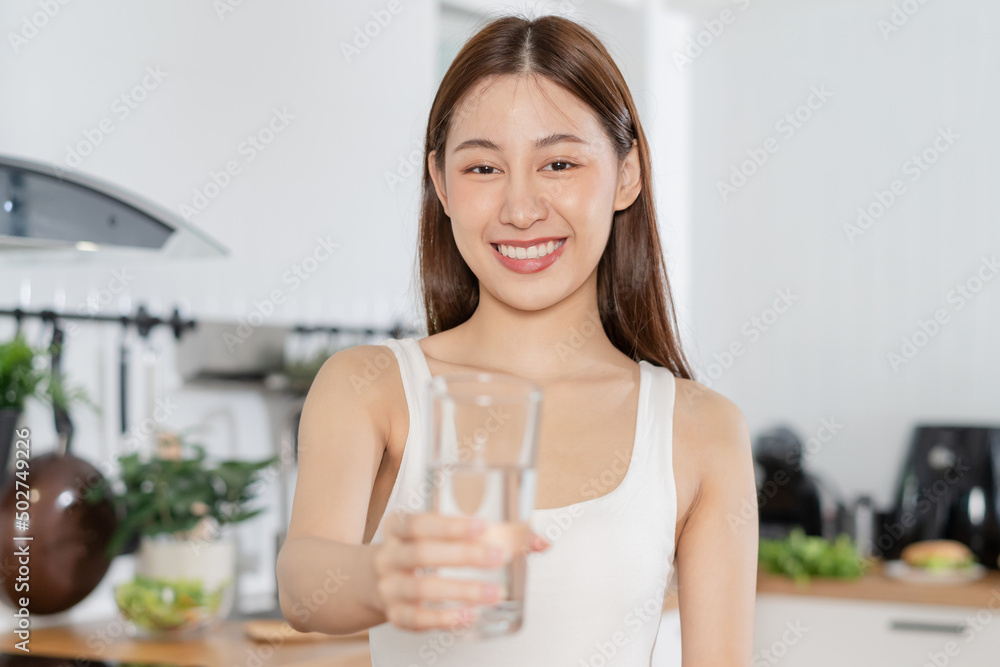 Happy beautiful, asian young woman, girl drinking, sip fresh glass of water for hydrate, holding transparent glass in her hand, thirsty at home. Health care, healthy lifestyle concept. Happy beautiful, asian young woman, girl drinking, sip fresh glass of water for hydrate, holding transparent glass in her hand, thirsty at home. Health care, healthy lifestyle concept.