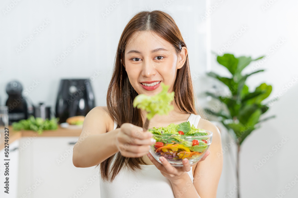 Diet, Dieting asian young woman or girl use fork at lettuce on mix vegetables, green salad bowl, eat food is low fat good health. Nutritionist female, Weight loss for healthy person. Diet, Dieting asian young woman or girl use fork at lettuce on mix vegetables, green salad bowl, eat food is low fat good health. Nutritionist female, Weight loss for healthy person.