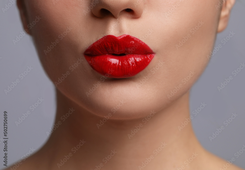 Obraz premium Closeup view of beautiful woman puckering lips for kiss.on grey background