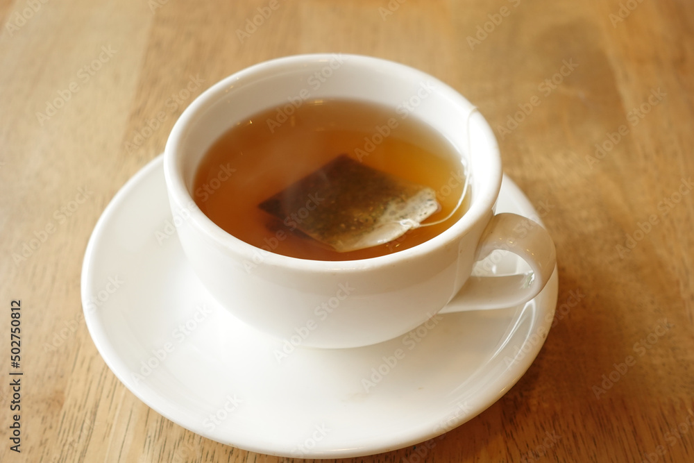 green tea with tea bag on tiles background green tea with tea bag on tiles background