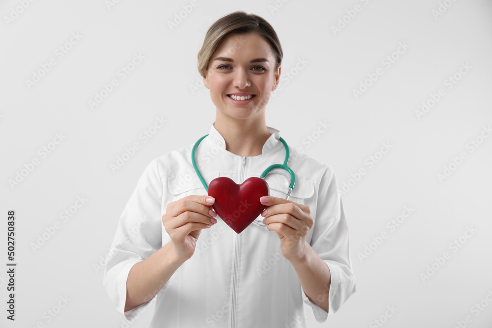 Doctor with stethoscope and red heart on white background. Cardiology concept Doctor with stethoscope and red heart on white background. Cardiology concept