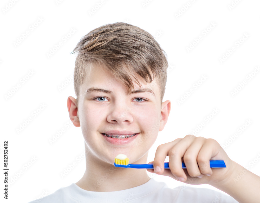Orthodontic treatment. Dental Care Concept. Young smiling boy with brackets holds toothbrush Orthodontic treatment. Dental Care Concept. Young smiling boy with brackets holds toothbrush