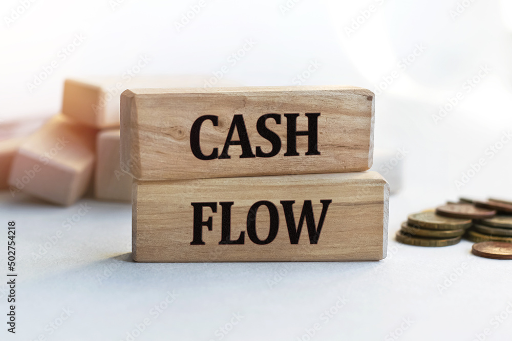 The inscription CASH FLOW on wooden cubes isolated on a light background. Concept word forming on wooden cube. Business, economics and finance concept. The inscription CASH FLOW on wooden cubes isolated on a light background. Concept word forming on wooden cube. Business, economics and finance concept.