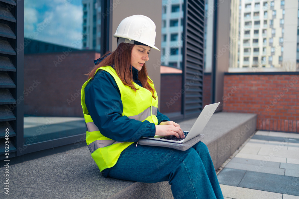 Industrial engineer woman using tablet computer at work on major construction site 
