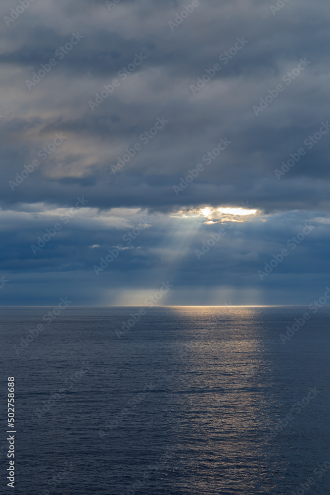 The sun's rays through a cloudy sky over the sea The sun's rays through a cloudy sky over the sea