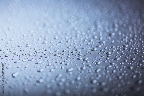 Abstract macro shot closeup of water drops on a metallic surface.