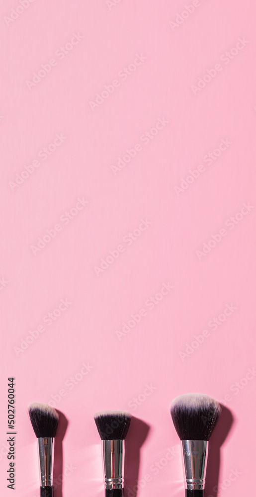 Various make-up brushes on pink background banner and place for advertising top view. Cosmetics and beauty concept. Various make-up brushes on pink background banner and place for advertising top view. Cosmetics and beauty concept.