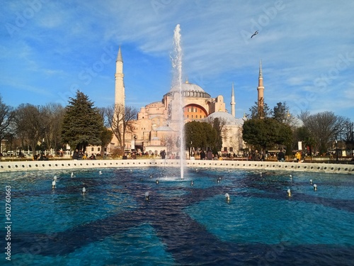 Istanbul Turkey, AyaSofya Haqia Sophia Constanipole view blue water fountain in front of mosque birds in the sky, blue colored sky and water along with green treens and minaretes tourists visiting.