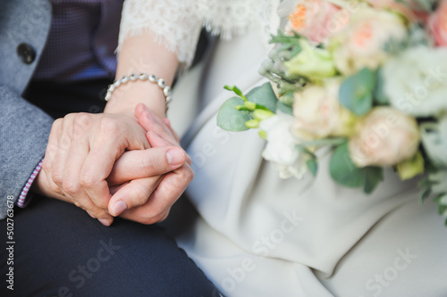 Closeup shot of a bridegroom holding bride's hand. Wedding ring. Tenderness concept