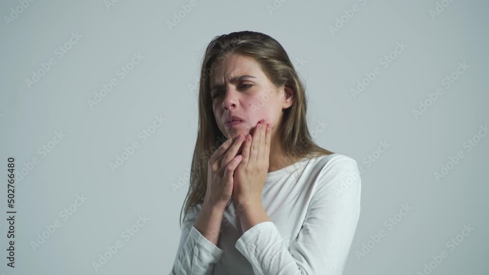 Girl suffering from toothache, tooth decay or sensitivity. Toothache, Woman with Tooth Infection. Woman suffering from toothache against gray background. Young woman suffering from toothache Girl suffering from toothache, tooth decay or sensitivity. Toothache, Woman with Tooth Infection. Woman suffering from toothache against gray background. Young woman suffering from toothache