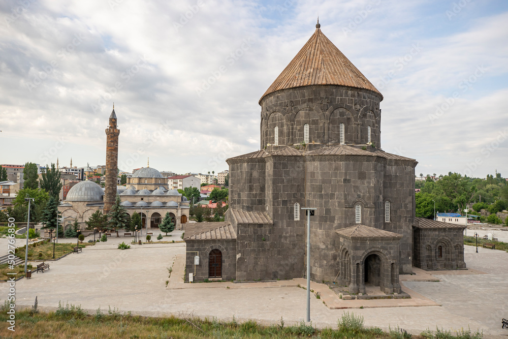 Ancient stone bridge across Kars River & Kars Castle - main tourist attractions of Kars, Turkey. Near flag (on castle) are portrait of Ataturk & writing in Turkish 'Motherland remembers you'