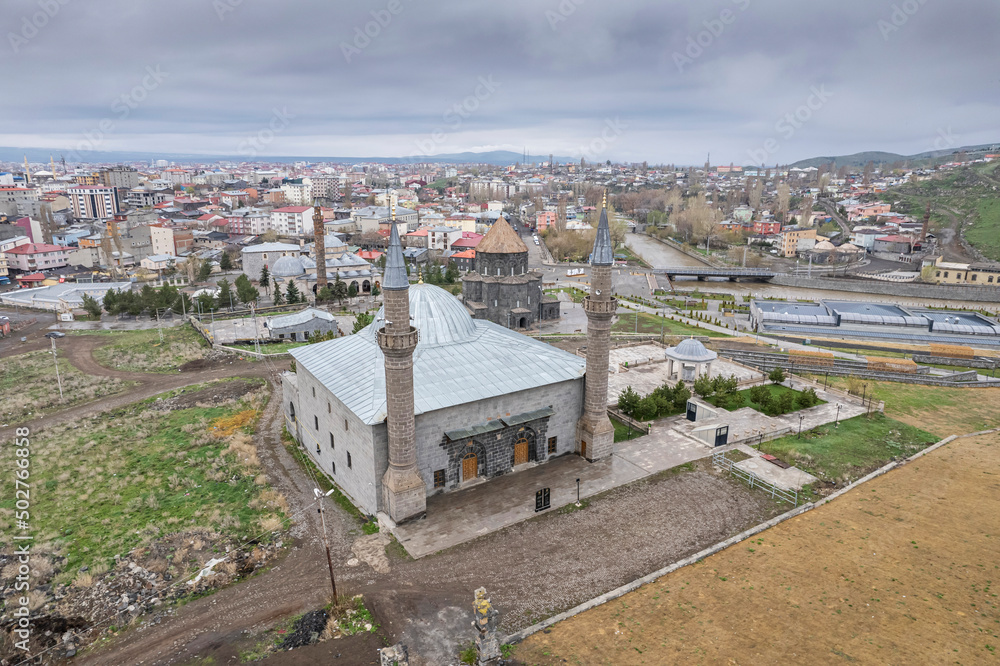 Ancient stone bridge across Kars River & Kars Castle - main tourist attractions of Kars, Turkey. Near flag (on castle) are portrait of Ataturk & writing in Turkish 'Motherland remembers you'