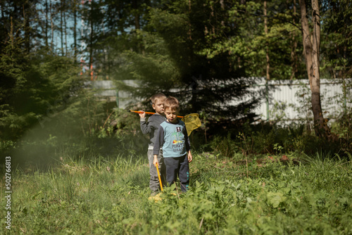 little boys with butterfly nets in countryside. Image with selective focus © Yulia Raneva