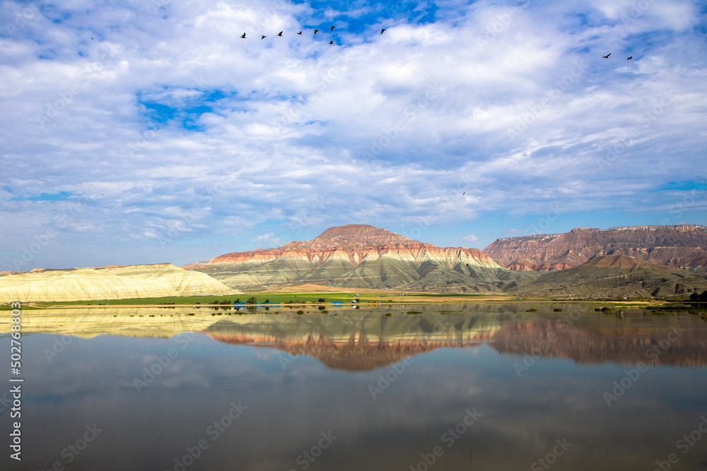 Blue clouds with reflection of colorful mountain in lake	