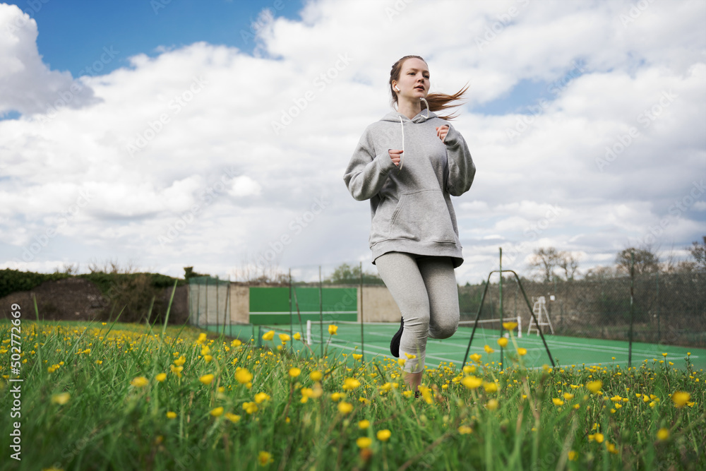 Caucasian teen girl have her morning run at the summer field Caucasian teen girl have her morning run at the summer field