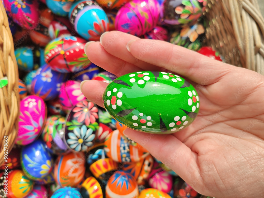 Green decorated Easter egg in hand on traditional Easter market in Krakow