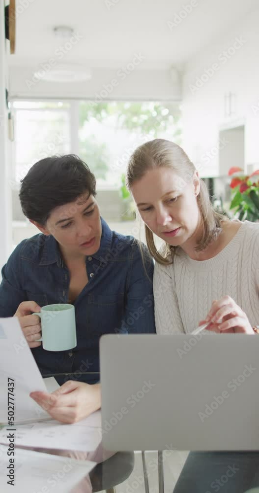 Vertical video of caucasian lesbian couple working on laptop at home Vertical video of caucasian lesbian couple working on laptop at home