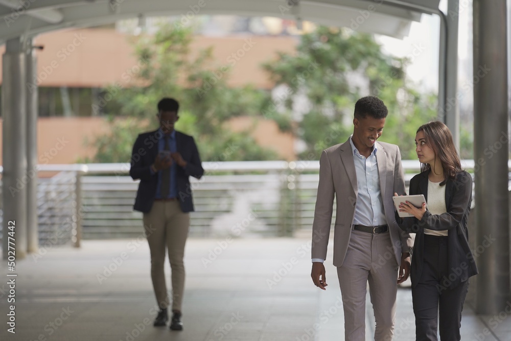 Smart business team discussion using digital tablet and walking outside office. Business people concept. Smart business team discussion using digital tablet and walking outside office. Business people concept.