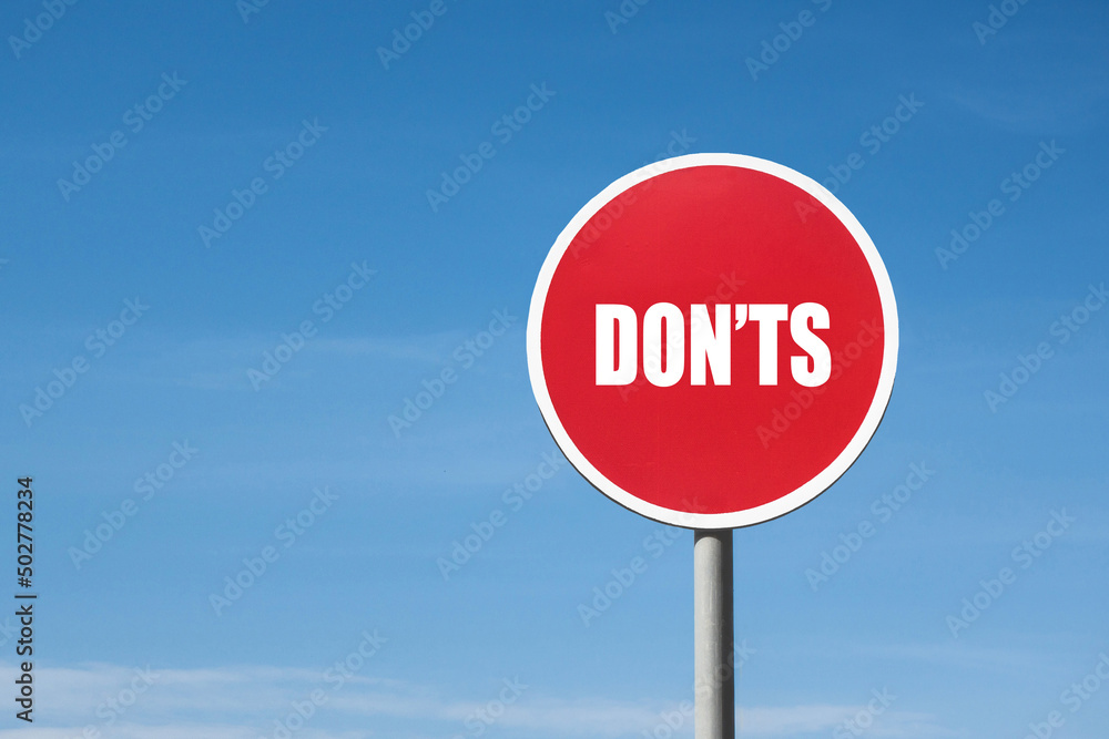 'Dont's' sign in red frame. Blue sky is on background 'Dont's' sign in red frame. Blue sky is on background