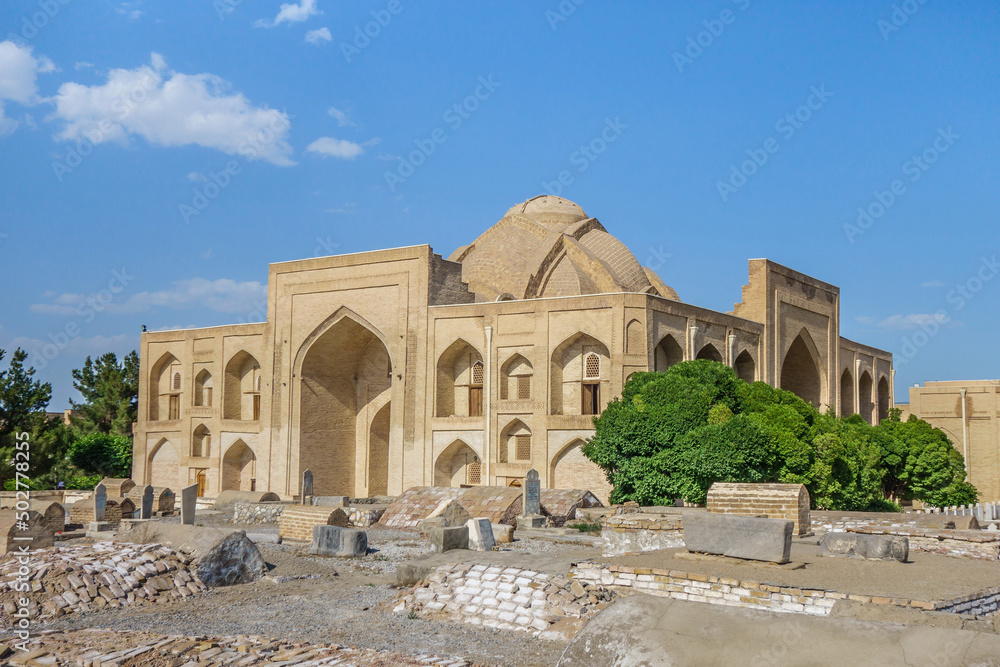 Medieval building of Khanqah of Abdulaziz Khan in Bukhara, Uzbekistan. It was built especially for pilgrims. This is part of Bahoutdin Architectural Complex. Medieval tombs visible in foreground