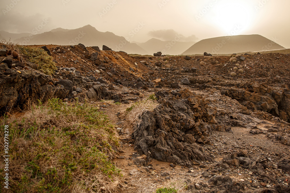 Volcanic landscape, sandstorm at sunset.