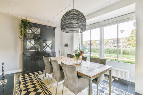 Spacious white kitchen with dining zone and tiled floor in house photo