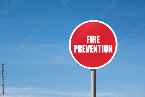 'Fire prevention' sign in red round frame. Clear blue sky is on background