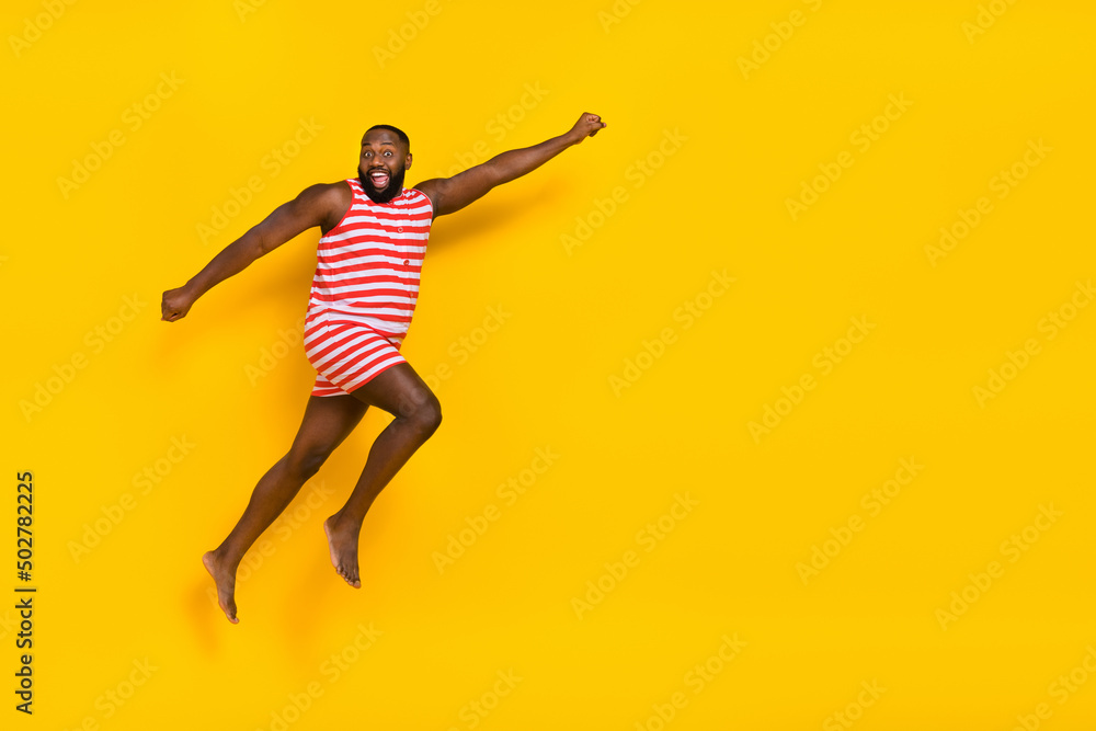 Photo guy super hero jump fly ahead empty space wear red swim wear striped suit isolated vivid color background