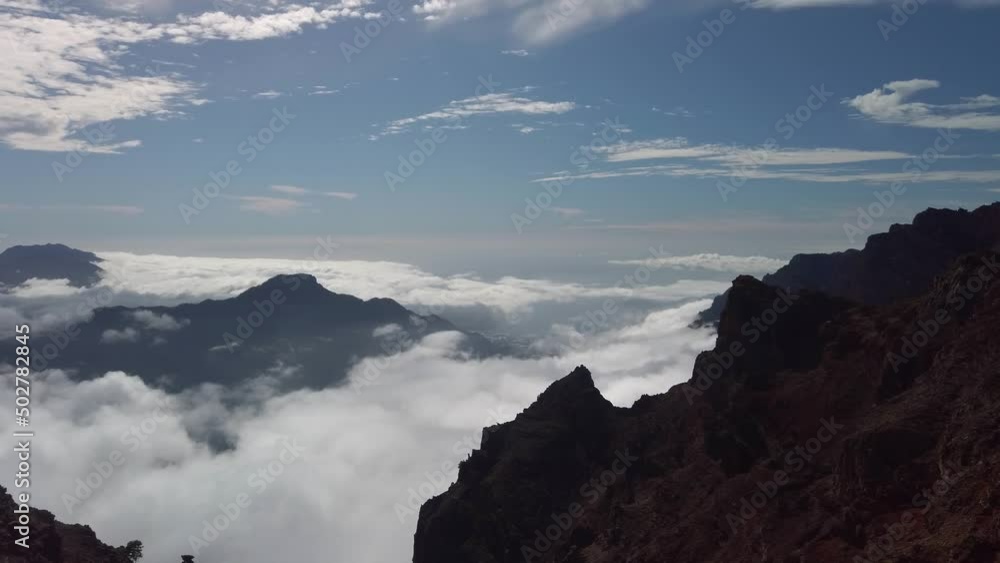Looking down as the clouds swirl around the rocks. Real time. Pan Left