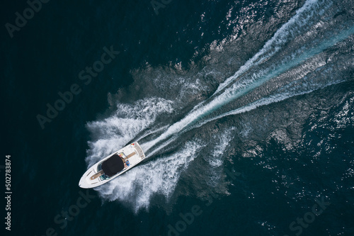 Wallpaper Mural Speedboat on dark water aerial view. Boat trip at sea. White boat with a black awning movement on the water drone view. Torontodigital.ca