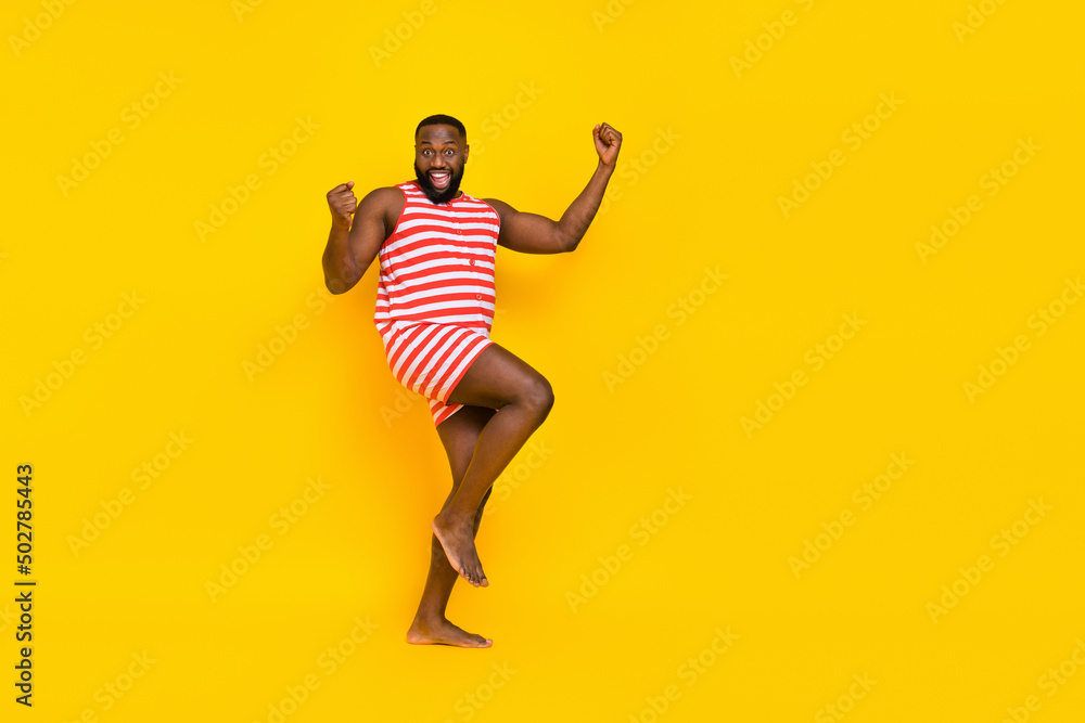 Photo guy fist up scream yes swimmer ocean distance win wear red striped set shorts isolated vivid color background