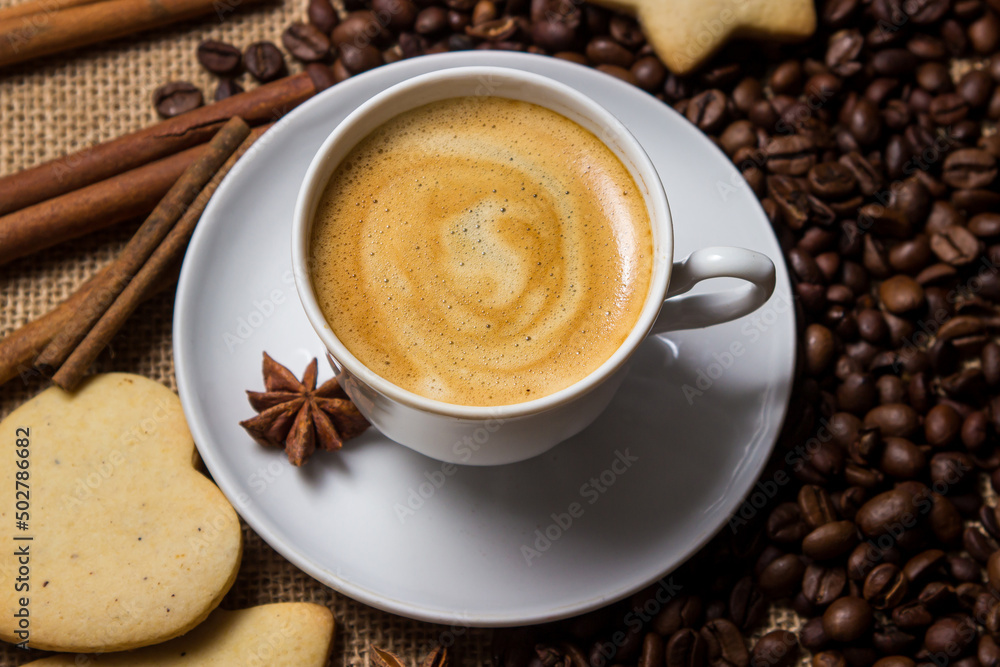 Espresso coffee on the background of coffee beans. A cup of coffee with cinnamon. invigorating drink Espresso coffee on the background of coffee beans. A cup of coffee with cinnamon. invigorating drink