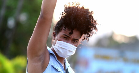 African American woman raises fist in air in political movement, black person activist