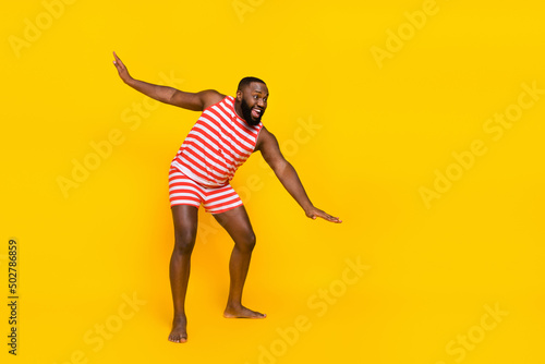 Photo of sporty fit guy stretch arms before swim ocean wear red striped set overall isolated shine color background