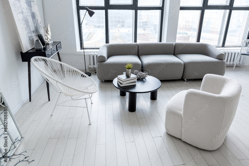 Fototapeta premium modern minimalistic interior design of light bright monochrome room with black and white furniture, clean white walls and huge windows
