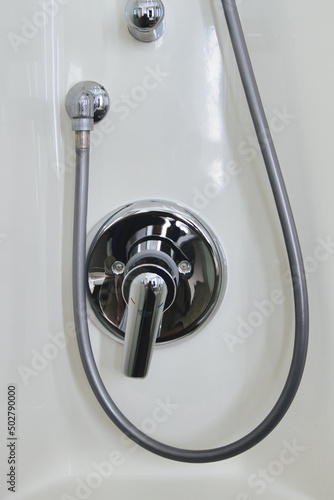 Modern shiny mixing faucet or mixer tap for the shower in a bathroom