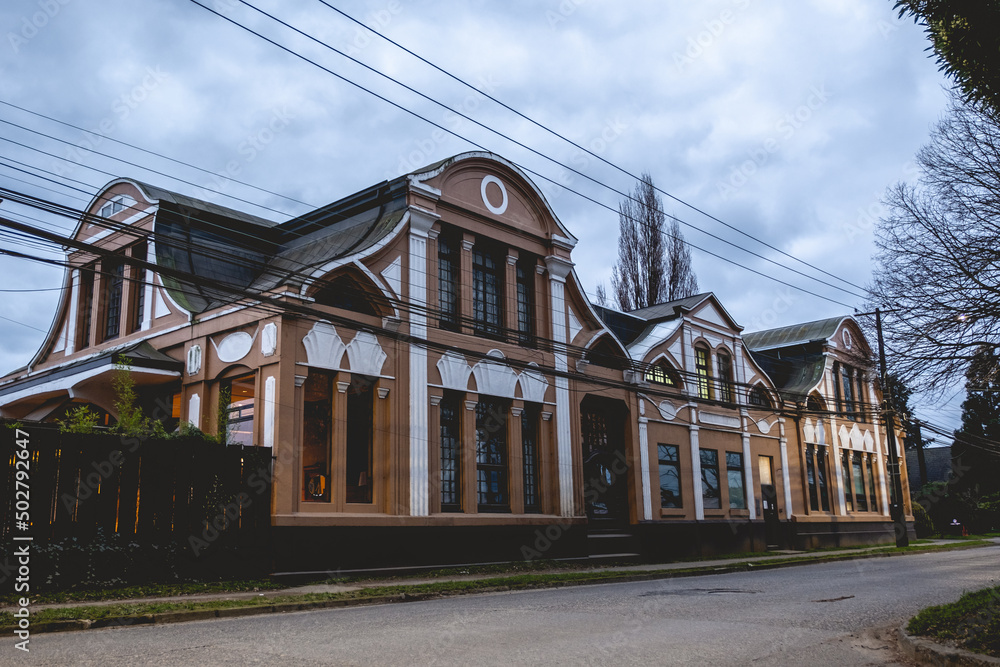 Beautiful old centuries building with neoclassical architecture style, columns, ornaments and big windows, and cloudy sunset sky, Valdivia, Chile