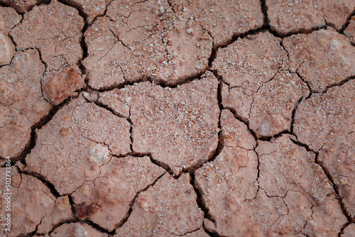 Obraz na płótnie Top view cracked red soil. Picture of natural disaster. Drought land, global warming and deforestation. Image of brown soil texture, close up. w salonie