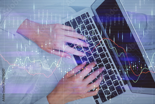 Double exposure of woman hands working on computer and forex chart hologram drawing. Top View. Financial analysis concept.