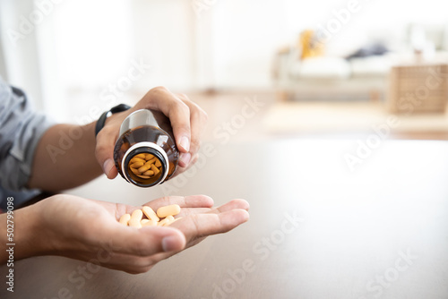 Close up, Doctor holding frug medicine bottle or Herbal supplement pill for patient at home. healthcare and treatment