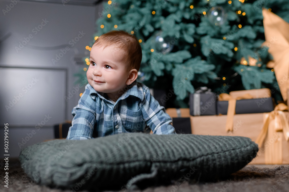 Naklejka premium Toddler kid boy on the background of the Christmas tree. High quality photo