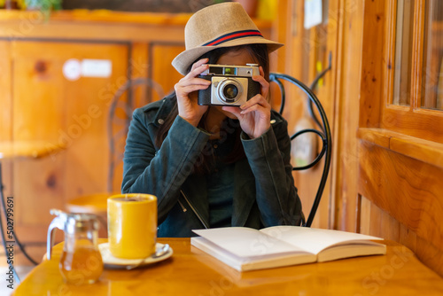 Canvas Print A tourist girl with a photo camera having a tea in a cafeteria terrace