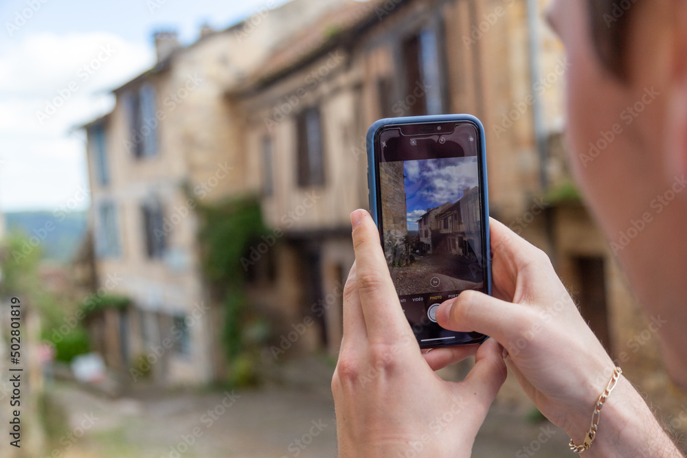 Un touriste photographie une rue de la cité médiévale de Cordes-sur-Ciel, dans le Tarn, en Occitanie
