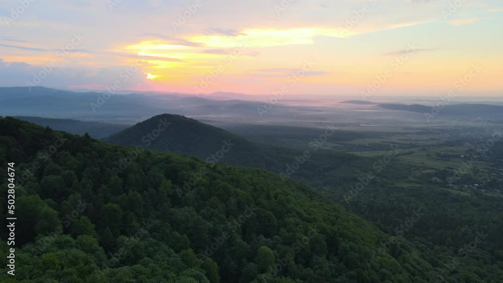 Aerial view of green pine forest with dark spruce trees covering mountain hills at sunset. Nothern woodland scenery from above Aerial view of green pine forest with dark spruce trees covering mountain hills at sunset. Nothern woodland scenery from above