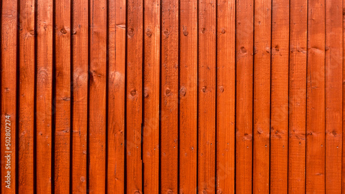 Wooden fence treated with water-based red cedar paint photo