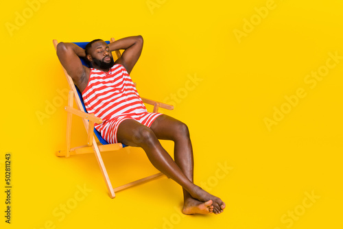 Foto Photo guy sit deck chair sleep sun bathing wear red striped stylish trendy swim