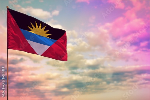 Fluttering Antigua and Barbuda flag mockup with the space for your content on colorful cloudy sky background. photo