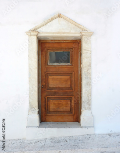 An elegant classic house entrance with brown wood door, Chora town, Andros island, Greece.