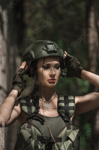 Military girl in uniform near a stone wall during the day. Portrait