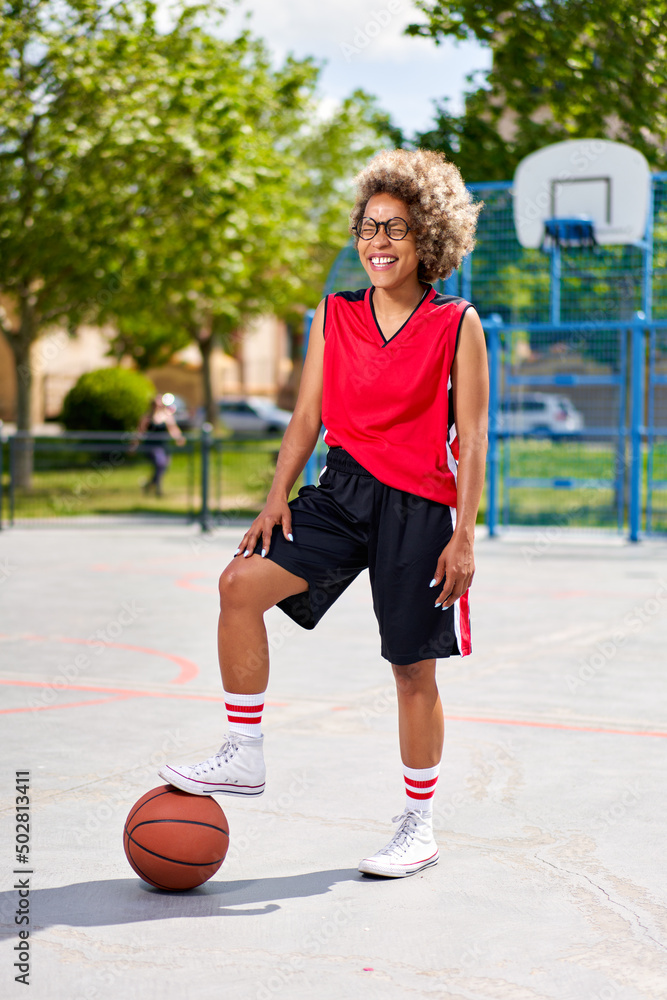 girl with afro hairstyle with a ball on a basketball court